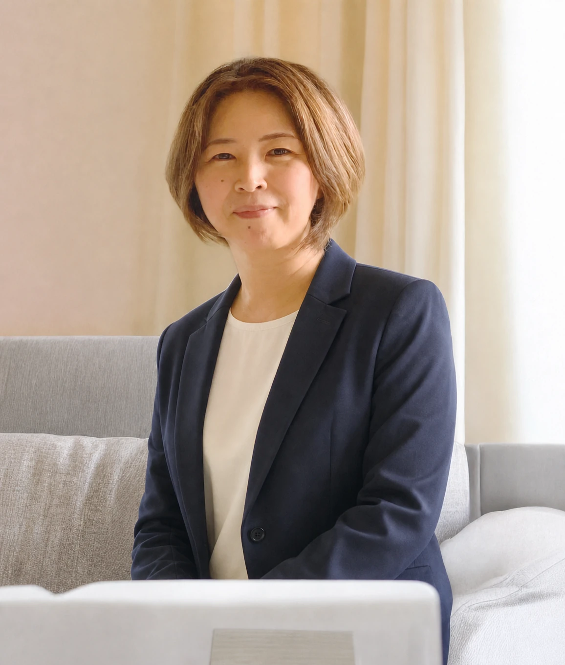紺色のスーツを着たまるまるデザイン代表